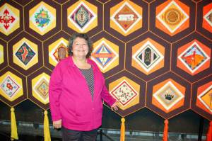 Shirley Pitawanakwat proudly points to her contribution to the Quilt of Belonging; a block representing the Odawa people. The vines in her block tell the story of how we are all connected.