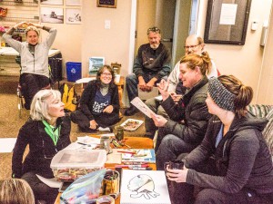 In the cozy comfort of the Gore Bay Airport lounge, Sophie Edwards (holding paper) describes “creative mapping” to excursion participants.