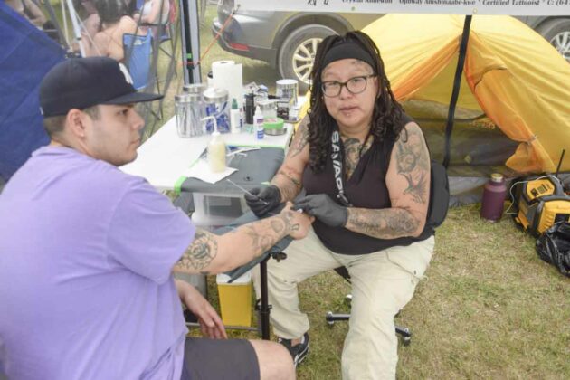 Certified tattooist and body piercer, Anishinaabe kwe, social worker, social justice advocate, art-based peer engagement facilitator, the one and only Crystal Kimewon works on Mason.