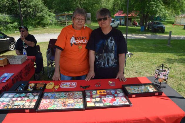 Vendors Christina Pheasant and Juanita Pheasant display their wares at the Buzwah Powwow. The duo create intricate beadwork while enjoying downtime. photo by Michael Erskine