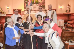 Members of the Diocesan Order of Service grasp the bishop’s mitre as they welcome Dianne Musgrove as the newest member of their order to the fold as local Jesuit priests and Bishop Jean Louis Plouffe look on.