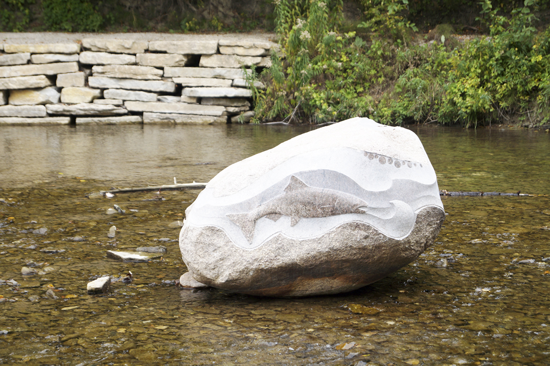 One of three boulders created by Thunder Bay’s Michael Belmore has a place of distinction at the mouth of the river which flows into Mudge Bay. The fish detail is quite fitting during this time of year when the salmon are spawning. 