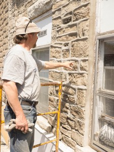 Alain Desaulniers, master stonemason, at work on restoring the mortar and limestone facade of the old Stone Block in Gore Bay, now home to two new businesses. photos by Isobel Harry