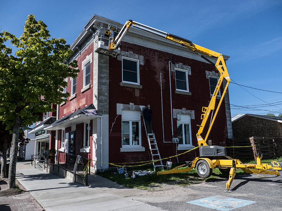 Outside renovations of the old bank building on Gore Bay’s  Meredith Street were carried out by Bobbie Hannigan and crew with a lift.