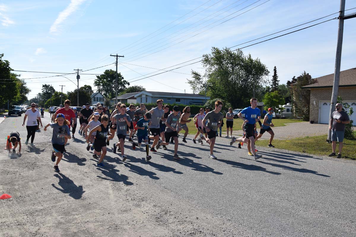 The 5K Haw Run runners set out from the starting line outside the NEMI Public Library. photo by Michael Erskine