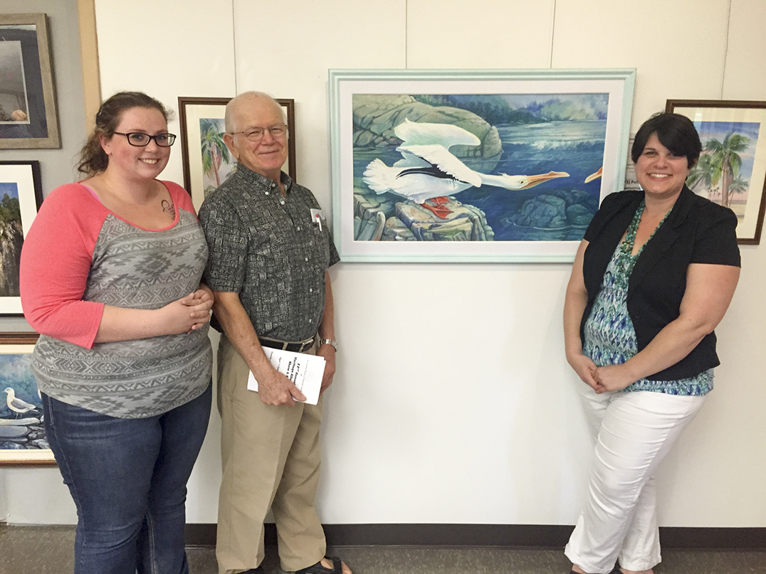 Peter Bering, centre, poses with summer student Jessica Myers, left, and museum curator Heidi Ferguson for his piece ‘Pelican  Conversation,’ which took the Students’ Choice award.