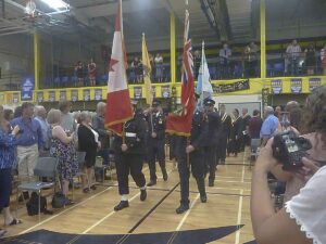 The Honour Guard marching in followed by the graduates. 