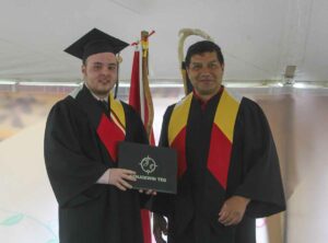 Kenjgewin Teg Secondary School graduate Charlie Halverson receives his Ontario Secondary School Diploma from Kenjgewin Teg Dean of Pathways Mark Gibeault. Charlie gave the address at graduation on behalf of the secondary school graduates. photo by Veronica Roy