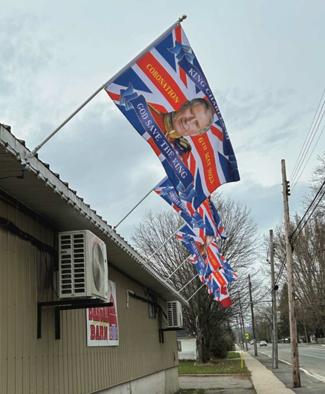 Flags marking the coronation of King Charles III line the side of Barney’s Bargain Barn in Little Current.