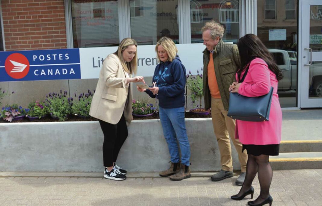 Debby Turner, second from left, shows Canada Post visitors Jenny Waters, left, Graeme Fleming and Melissa Levesque a business letter that would have gone through the post office in 1897 en route to Turner’s Store. Ms. Turner explained to the visitors that their business, in its seventh generation, and The Manitoulin Expositor are Canada Post’s oldest business customers on Manitoulin as both businesses were established in 1879.