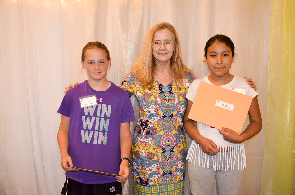 Children’s art honourable mention winners Maggie Chapman for her piece ‘Little Town’ poses with Kerry Butler, a member of the art  committee and judge, and fellow winner Rheanne Green for her piece ‘Starry Night in Paris.’