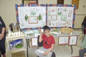 Edison Ense offers Lakeview School visitors a cup of giizhik (cedar) tea. photo by Michael Erskine