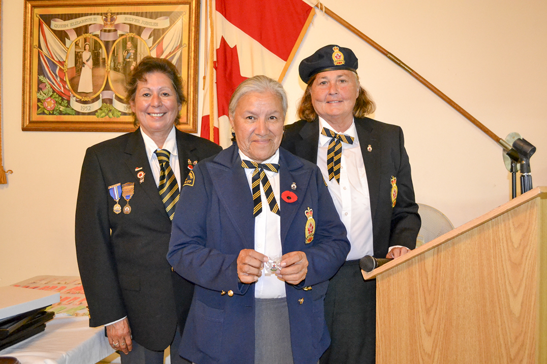 Legion President Debbie Menard, left, and Ladies’ Auxiliary  President Nancy Millburn, right, present Marie Eshkibok with a membership pin.