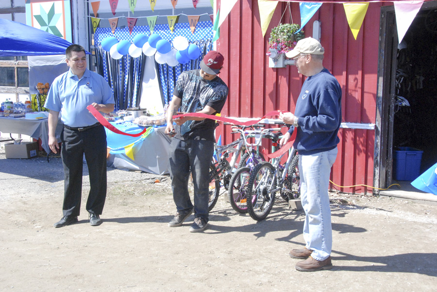 Josh Shaw gets a helping hand from, left, Wikwemikong Chief Duke Peltier and, right, Assiginack Reeve Paul Moffat during the ribbon cutting ceremony.