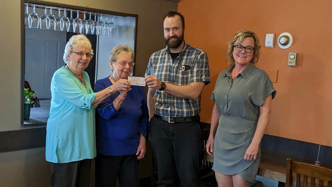 Members of the Auxiliary and the Manitoulin Health Centre hold a cheque passing.