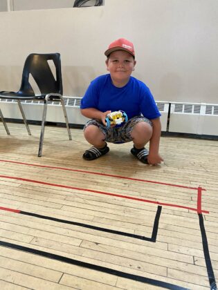 A Grade 4 student with his maze and programmed robot.