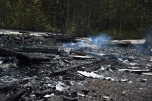 The remaining smouldering pile of ash from the suspected arson on M'Chigeeng First Nation. photo by Michael Erskine.