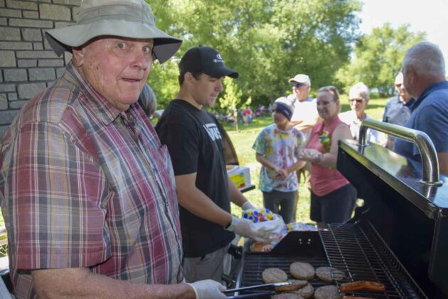 Councillor Bill Koehler flips burgers and hot dogs at the Town of Northeastern Manitoulin and the Islands community picnic July 9 at Low Island. photo by Michael Erskine