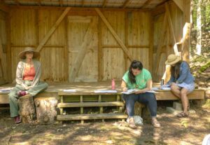 Environmental artist Sophie Edwards, left, leads a workshop at Kagawong’s Riverbend stage during the NorthWords Festival. photo by Isobel Harry