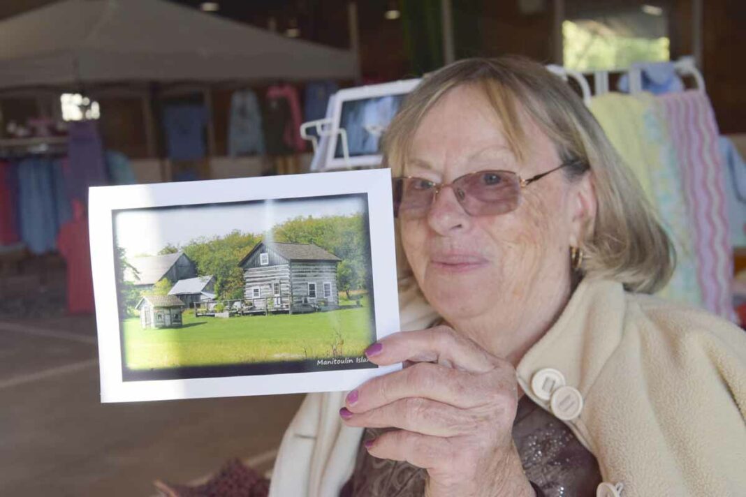 Evelyn Russell-Baehr holds up one of her greeting cards featuring her home.