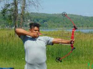 Noah Shawanda practices his archery skills during the Noojmowin Teg Wellness Day in Sheguiandah. photo by Margery Frisch