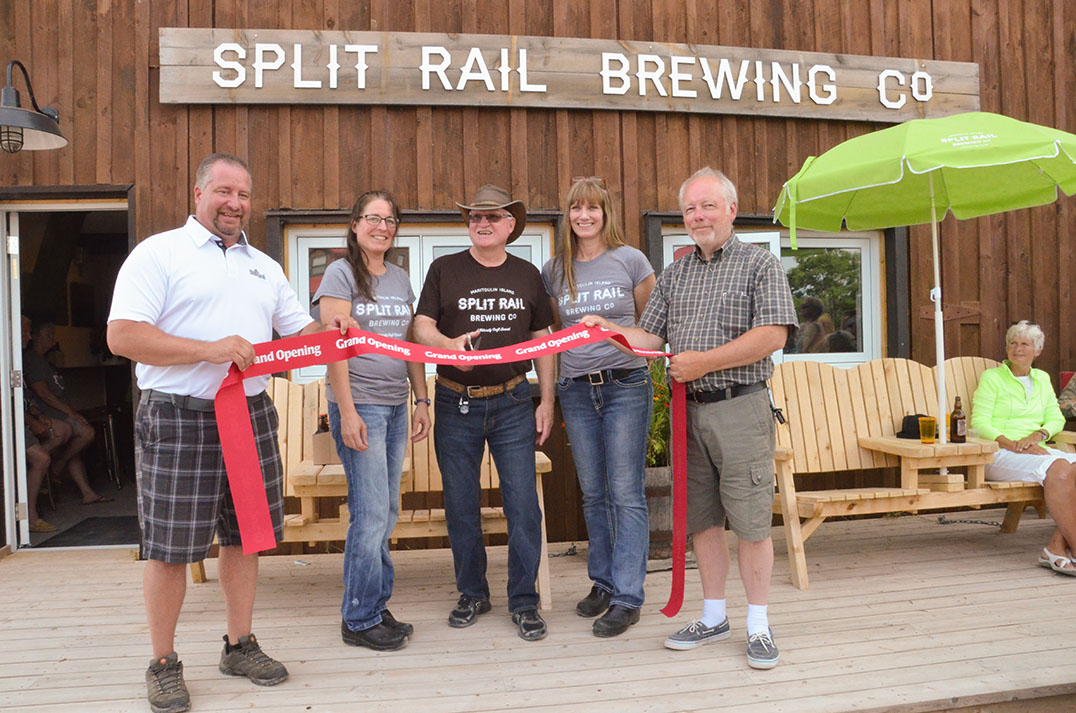 Algoma-Manitoulin Kapuskasing MPP Mike Mantha joins Split Rail Brewery co-owner Andrea Smith, brewmaster Glenn Fobes, co-owner Eleanor Charlton and Gore Bay Mayor Ron Lane in cutting the ribbon to officially open the brewing facility in Gore Bay.  photo by Michael Erskine