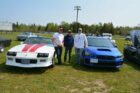 Joey Stoneypoint, left, poses with his 1992 Chev Camaro alongside father-in-law Ted Corbiere and son Samuel Stoneypoint and his 2022 Subaru WRX STI at the car show.