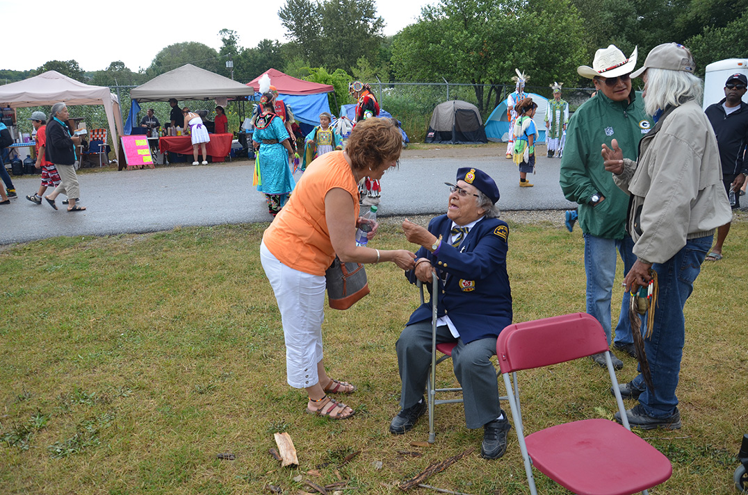 NDP incumbent Carol Hughes chats with an elder before the grand entry at the Wikwemikong Cultural Festival.