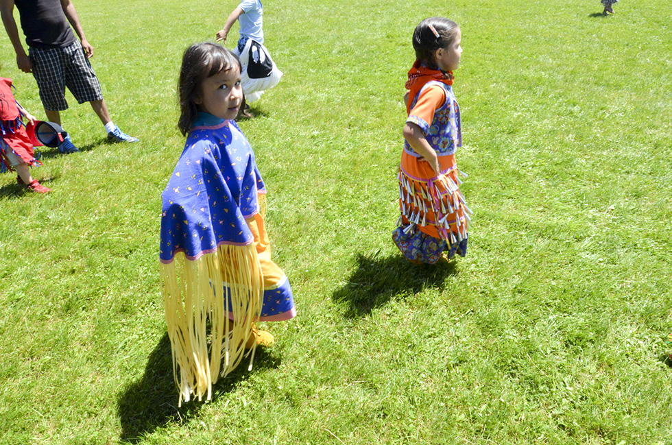 A young shawl and jingle dress dancer proudly make their way around the powwow arena.