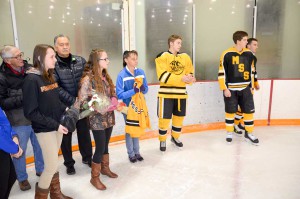 Hockey players and Wyatt Kennedy’s friends Thomas Hayden, Michael Niven and Cole Drummond present a team jersey signed by all of the players along with a bouquet of flowers to Wyatt’s mother Karen McGaughey and family members. The event raised an amazing $8,664 to help defray the family’s expenses in dealing with Wyatt’s cancer treatment. photos by Michael Erskine