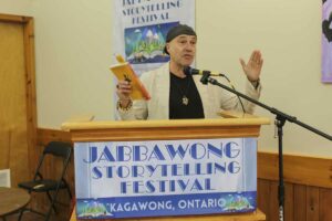 Rod Carley, an award-winning author of three works literacy fiction, a top 10 finalist for the 2023 Stephen Leacock Medal for Humour reads a passage from his book Grin Reaping at Jaggawong Storytelling Festival. photo by Tom Sasvari