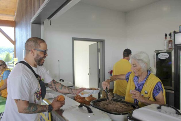 Gaynor Orford, right in photo, a member of the Gore Bay-Western Manitoulin Lions Club serves a customer some of the Lions famous beef on a bun.