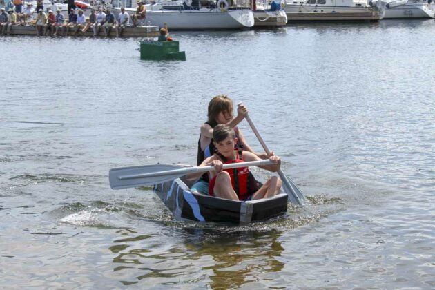 Rowan McCann and Finn Sweeney row their way to victory in the open race at the carboard boat regatta.