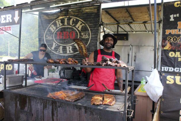 Brickyard Barbecue won the judges award for best sauce among the four professional ribbers on hand for Ribfest, as part of the Homecoming weekend. Ribber Mark Scarlett is shown preparing the ribs for hungry customers.