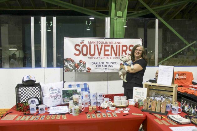 Darlene Munro of Darlene Munro Creations and her dog Snookie man their booth at the Central Manitoulin Market.