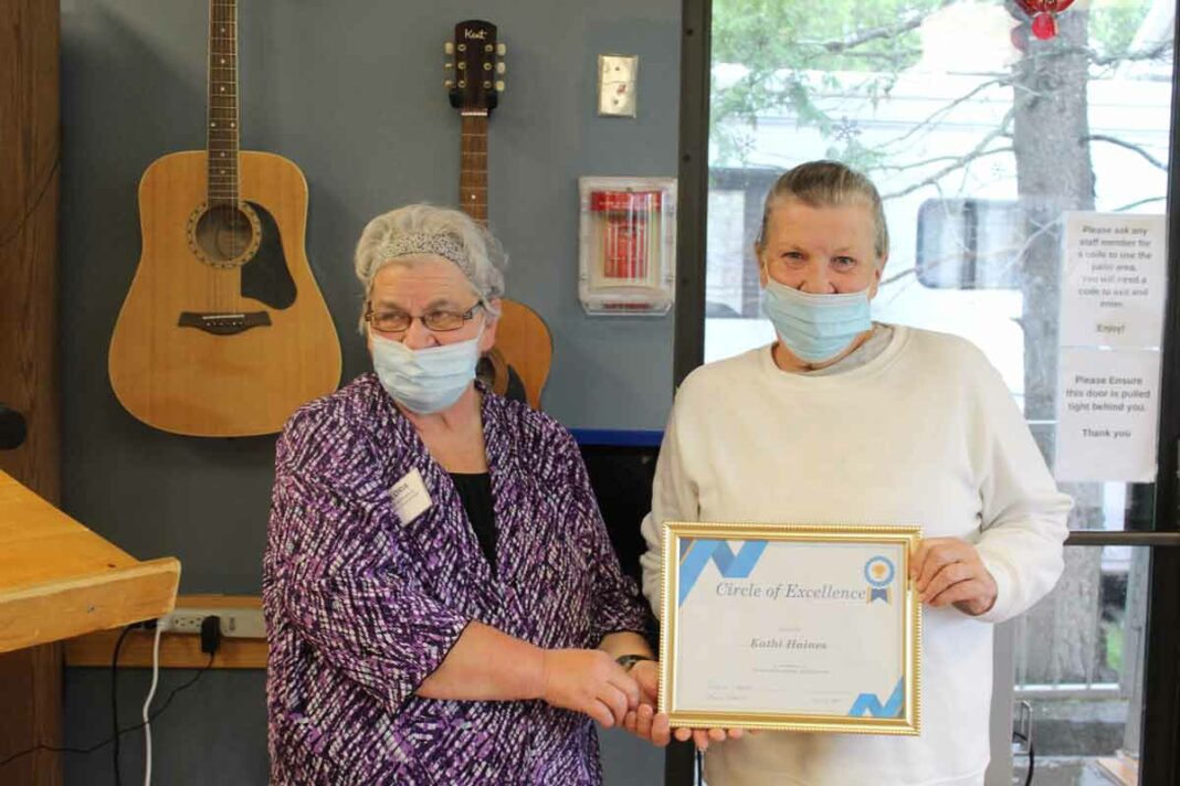 In photo, left, Gloria Hall, life enrichment coordinator at the Manitoulin Lodge Nursing Home in Gore Bay, presents a Circle of Excellence Award to volunteer Kathi Haines. photo by Tom Sasvari