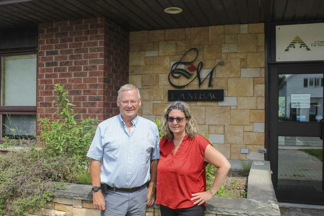 Mike Addison recently retired as general manager of LAMBAC, left, poses with his replacement, Carolyn Campbell former LAMBAC loans and business development officer in front of the community futures development corporation office.