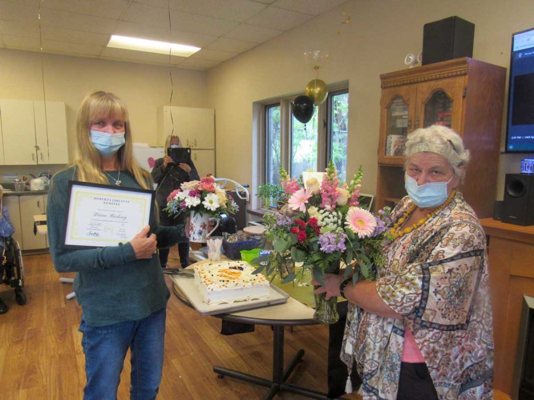 Mantoulin Lodge health care aid worker Diane Riching, left, receives a Roberta Jarlette Award from Gloria Hall, Lodge activities coordinator.