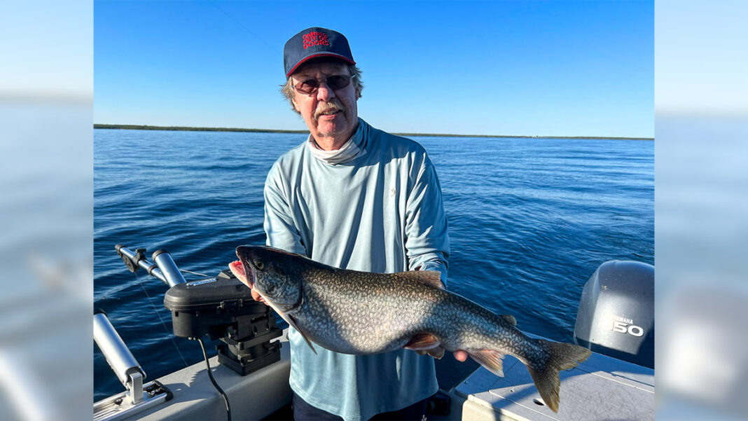 Man holds large fish on a boat out on the water