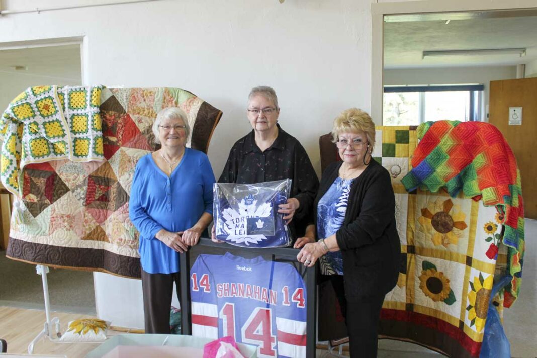 Its back! The Mindemoya Hospital Auxiliary annual luncheon, bazaar and bake sale was a huge success this past Saturday. In photo from left Jan McQuay, Mary-Alice Lewis and Evelyn Cardiff hold up several items, including two quilts, and autographed Brendan Shanahan and Austin Matthews jerseys.