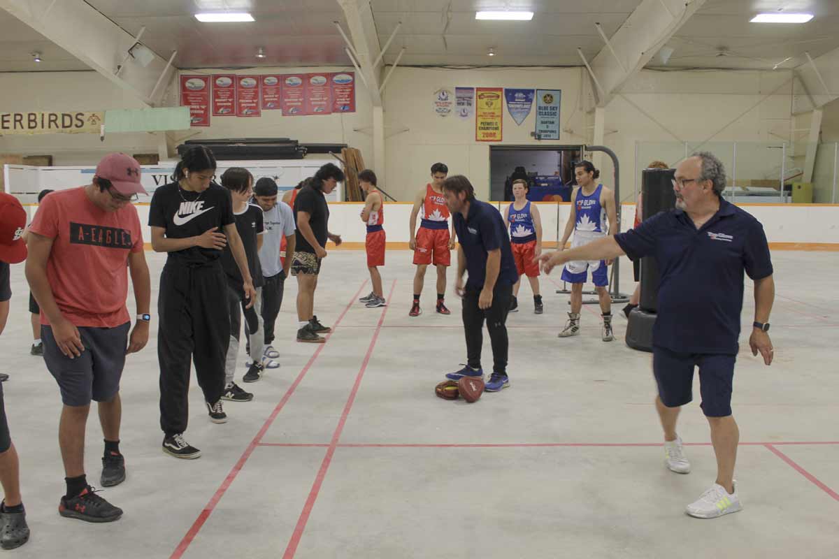 Gordon Apolloni of Top Glove Boxing (in photo right) demonstrates some of the proper footwork needed in boxing at the Olympic style boxing training session held at the M’Chigeeng arena last Friday evening.