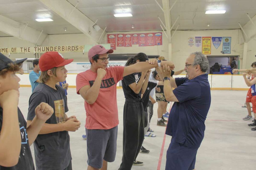 Gordon Apolloni of Top Glove Boxing, far right, instructs a student on how to throw a jab correctly at the Olympic-style boxing training session held in M’Chigeeng last Friday.