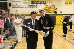 Coxswain Rhys Allison, right, presents a special decorative paddle to Reviewing Officer Roy Eaton. photo by Michael Erskine.