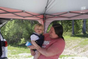 Trying to coax a smile out of a little one in the shade during the Manitoulin Service Providers Family Fun Day festivities. photo by Tom Sasvari.