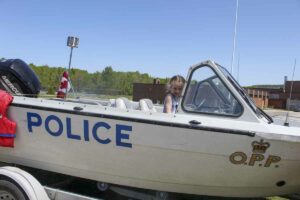 Young Katherine Ross is at the helm of the Manitoulin OPP police boat. photo by Tom Sasvari.