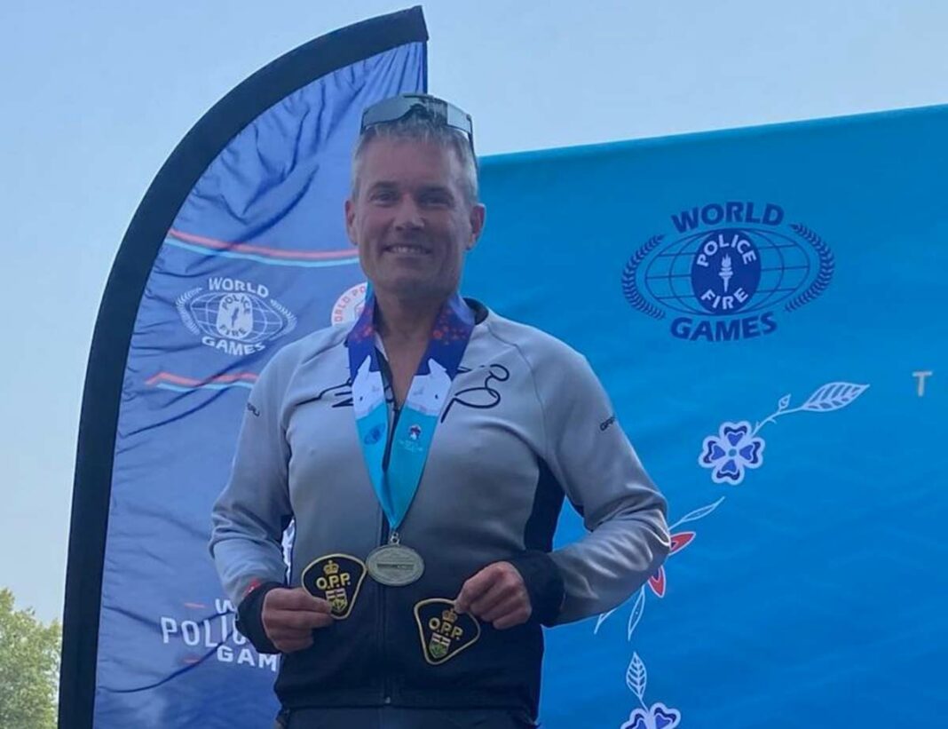 Steve Redmond of Mindemoya, who is a constable with the Manitoulin detachment of the Ontario Provincial Police stands on the podium after having won a silver medal in the triathlon at the World Police and Fire Games 2023.