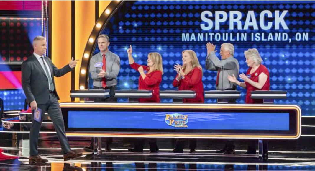 family of two men and three women play Family Feud in game show