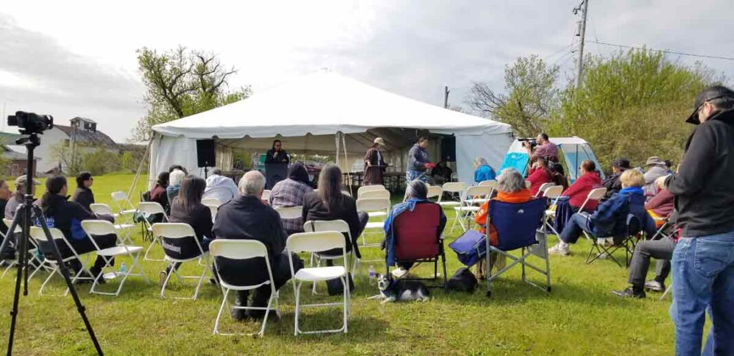 Dr. Alan Corbiere speaks about the 1836 ceremonial pipe while Naomi Recollet of the Ojibwe Cultural Foundation gets ready to carry the pipe into the audience for viewing. photo by Shelley Pearen.