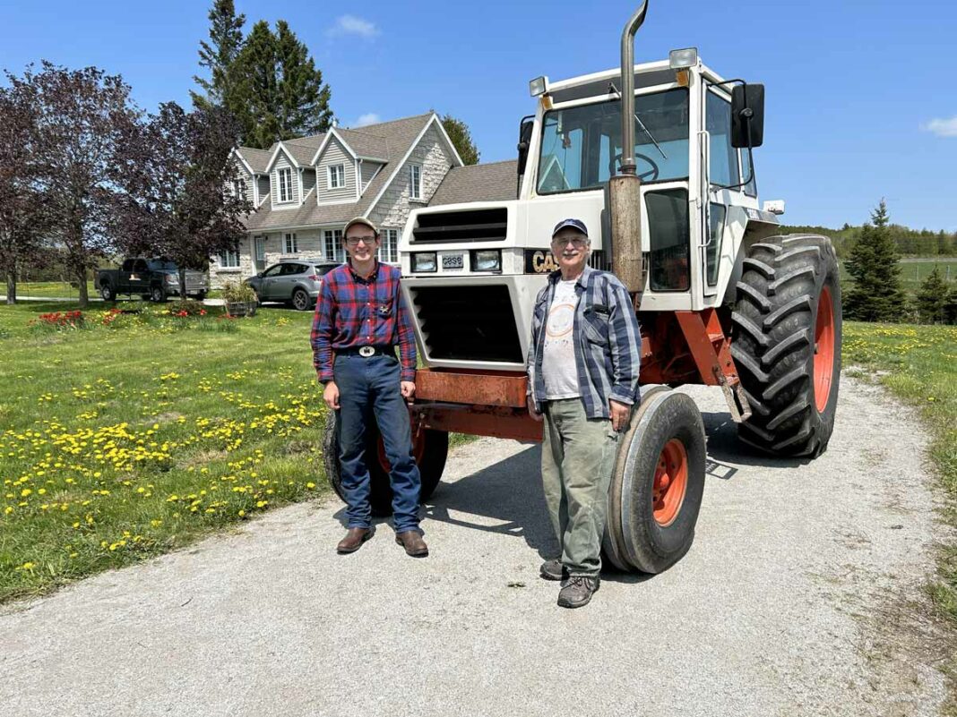 RIGHT AT HOME—Father and son Lyle and Johannes Renecker, right to left, have moved to their new farm in Tehkummah on the Blue Jay Creek. The farm will be named Palace Hillside Farm after the multi-generational Perth County farm where Lyle was raised. The tractor is significant as well: it’s a Case 2090 that Lyle and his late father Alfred purchased new in 1984 and has also made the move to the Island with the rest of the family. Lyle found the farm last fall after running an ad in The Expositor. 