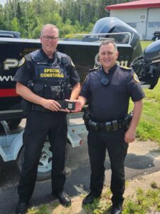 S/Cst. James (Jim) Hodder, left, is the newest special constable and court officer for Wikwemikong Tribal Police Service is presented with his badge by Acting Staff Sergeant Chris Wesley.